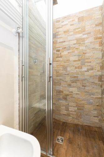 a bathroom with a shower with a wooden floor at Sweet Dreams in La Spezia