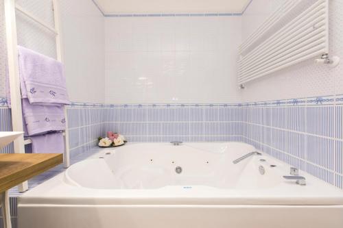 a white bath tub in a blue tiled bathroom at Sweet Dreams in La Spezia