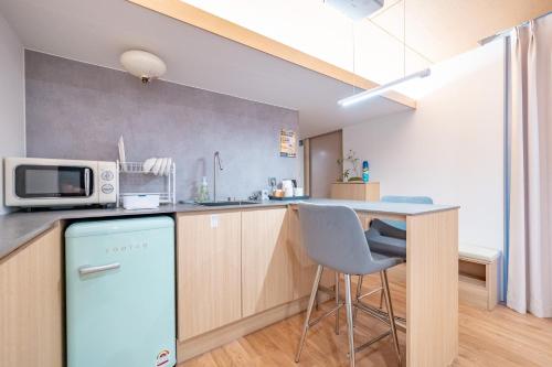 a kitchen with a blue refrigerator and a counter at Ocean Bliss in Ulsan