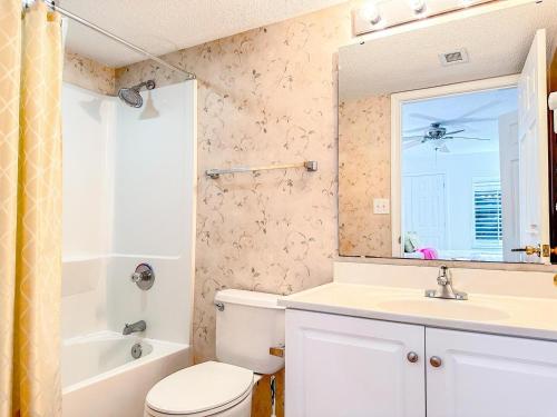 a bathroom with a sink and a toilet and a mirror at Ashworth 303 in North Myrtle Beach