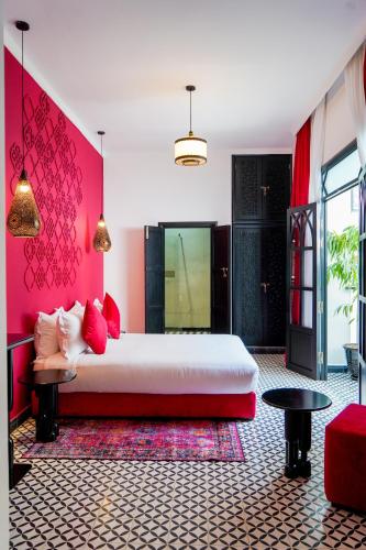 a bedroom with a large white bed and pink walls at Riad Looma in Marrakesh
