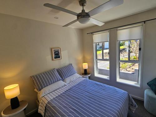 a bedroom with a bed and a ceiling fan at Summer Villa in Kiama