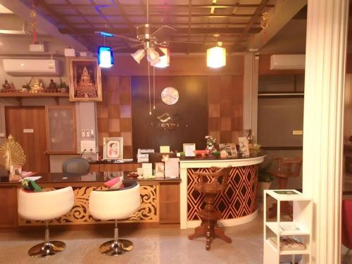 a kitchen with a counter and two bar stools at Waenpetch place Hotel in Ubon Ratchathani