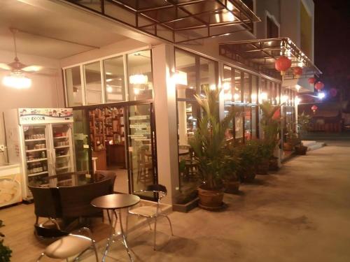 a store front with chairs and a table and plants at Waenpetch place Hotel in Ubon Ratchathani
