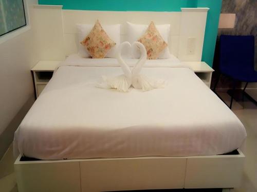 a white bed with two white swans on it at Waenpetch place Hotel in Ubon Ratchathani