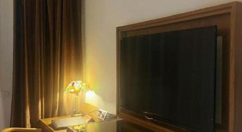 a large flat screen tv sitting in a living room at James Joyce Coffetel Beijing Yizhuang Rongjing East Street Subway Station in Beijing