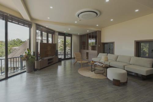a living room with a couch and a tv at Valley De Mango Hue in Thôn Châu Chữ