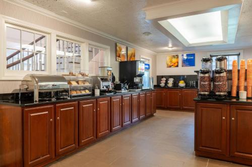 a kitchen with wooden cabinets and aasteryasteryasteryasteryasteryasteryasteryasteryastery at Comfort Inn Rockland - Boston in Rockland