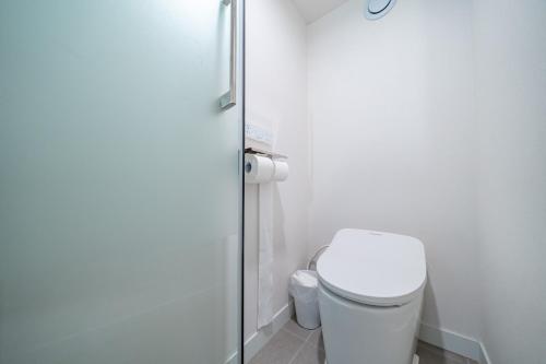 a bathroom with a toilet and a glass shower at Ocean Bliss in Ulsan