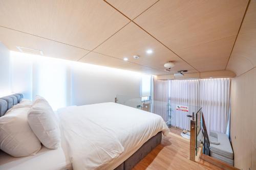 a bedroom with a large white bed in a room at Ocean Bliss in Ulsan