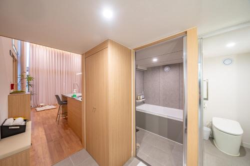 a bathroom with a toilet and a bath tub at Ocean Bliss in Ulsan