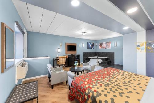 a bedroom with a bed and a living room at Econo Lodge Cranston - Providence in Cranston