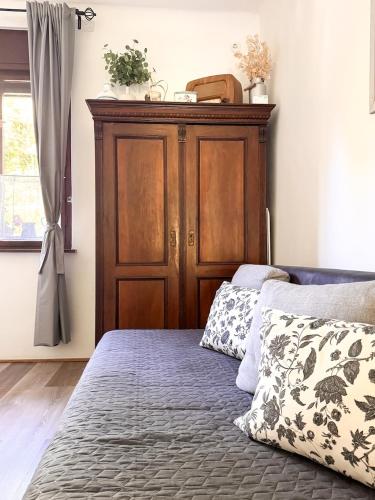 a bed with a wooden headboard in a bedroom at Halháza vendégház in Sirok