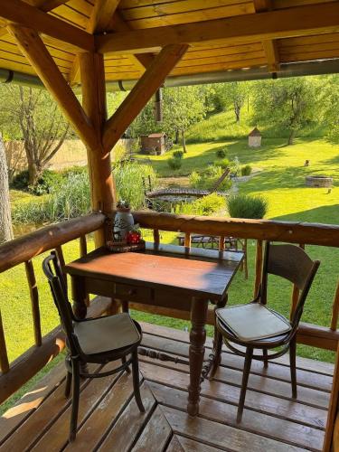 a wooden table and two chairs on a porch at Halháza vendégház in Sirok