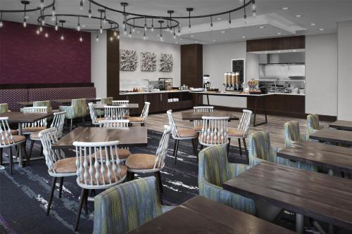 a dining room with wooden tables and chairs at Hilton Garden Inn Charlotte Waverly in Charlotte