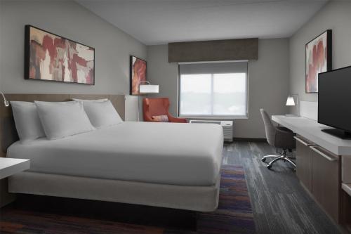 a hotel room with a bed and a desk at Hilton Garden Inn Charlotte Waverly in Charlotte
