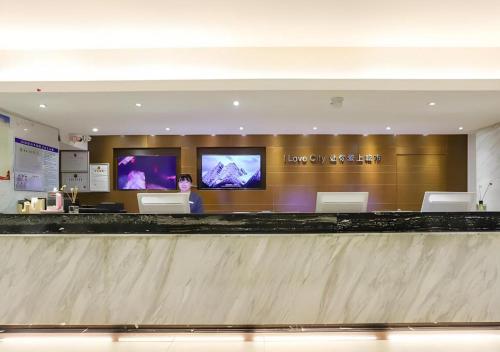 a check in counter at an airport with two televisions at City Comfort Inn Wuhan Hankou Railway Station West Square in Wuhan
