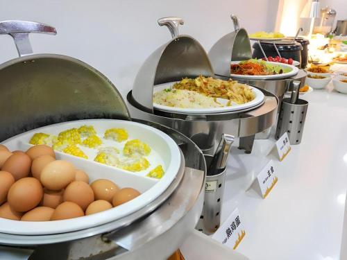 a buffet line with eggs and other breakfast foods at City Comfort Inn Wuhan Hankou Railway Station West Square in Wuhan