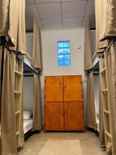 a room with two bunk beds and a wooden cabinet at Wake N Flow, Hiriketiya in Hiriketiya