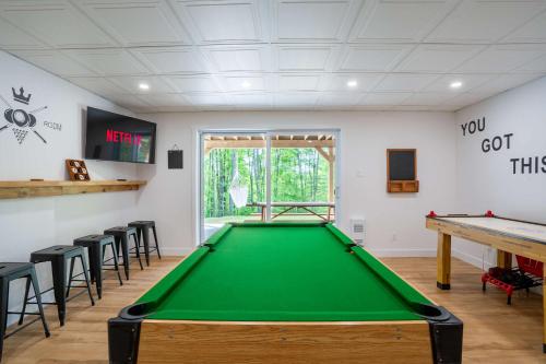 a pool table in a room with stools at Spa and Billard - Chalet Le Silverson in Brownsburg