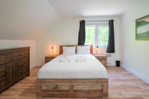 a bedroom with a bed with two towels on it at Spa and Billard - Chalet Le Silverson in Brownsburg