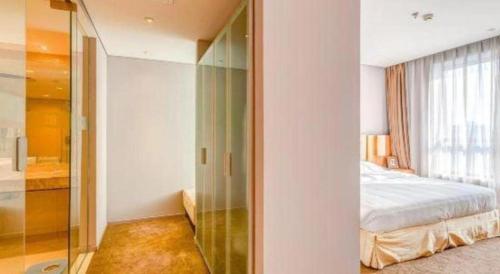 a bedroom with a bed and a glass closet at Tangshan Qiangang Hotel in Qian'an