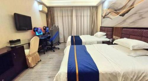 a hotel room with two beds and a desk with a computer at Oriental Hotel in Dongguan