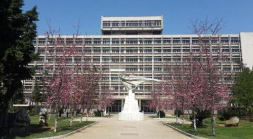 a large building with a statue in front of it at Kunming Wenhui Hotel in Kunming