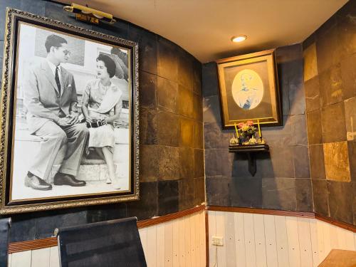 a picture of a man and a woman on a wall at โรงแรมรอยัลจอมมณี เฮอริเทจ in Ban Na Kai