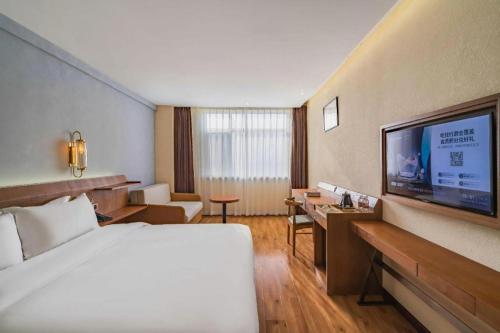 a hotel room with a bed and a flat screen tv at James Joyce Coffetel Tianjin Railway Station Jinshiqiao Metro Station Branch in Tianjin