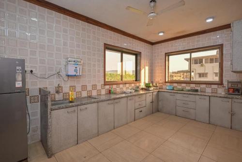 a large kitchen with stainless steel appliances and windows at Mountain Mansion - The Dream Stays ll Pvt Pool ll 4 Bhk ll Big Lawn in Khandala