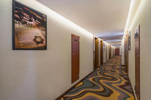 a hallway with a movie poster on the wall at James Joyce Coffetel Tianjin Railway Station Jinshiqiao Metro Station Branch in Tianjin