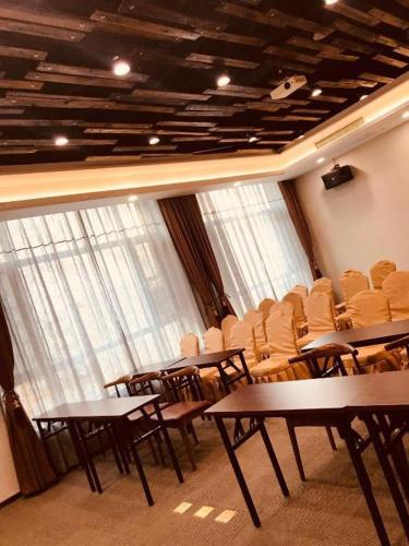 a conference room with tables and chairs and windows at James Joyce Coffetel Tianjin Railway Station Jinshiqiao Metro Station Branch in Tianjin
