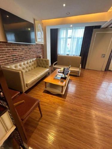 a living room with a couch and a coffee table at James Joyce Coffetel Tianjin Railway Station Jinshiqiao Metro Station Branch in Tianjin