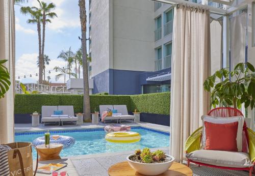 a patio with a pool with chairs and a table at Viceroy Santa Monica in Los Angeles