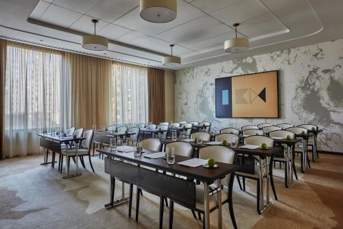 a conference room with tables and chairs and a screen at Viceroy Chicago in Chicago
