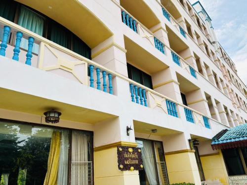 a building with blue windows and a balcony at โรงแรมรอยัลจอมมณี เฮอริเทจ in Ban Na Kai