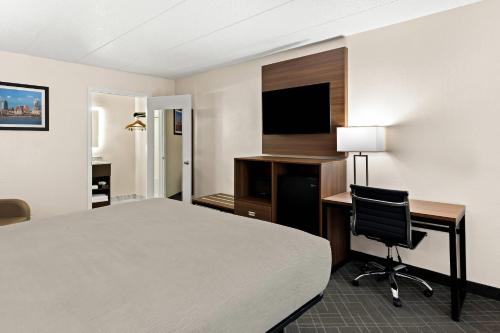 a hotel room with a bed and a desk and a television at Quality Inn Mason Near Kings Island in Mason