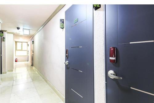 a corridor with two blue doors in a hallway at Dubai Motel in Daejeon