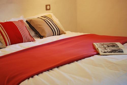 a bed with a red and white blanket on it at Gite Cap de la Hont in Laruns