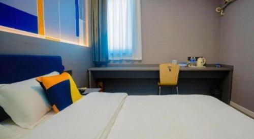 a bedroom with a large bed and a desk at 7 Days Inn Xi'an Railway Station in Xi'an