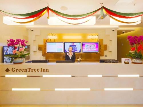 a green tree inn lobby with a woman at the counter at GreenTree Inn Shanghai Railway Station Macao Road in Shanghai