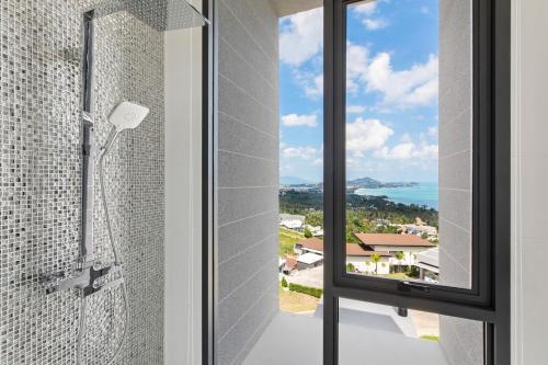 a glass shower with a view of the ocean at Villa Sea Esta Luxury Residence at Chaweng Noi in Koh Samui 