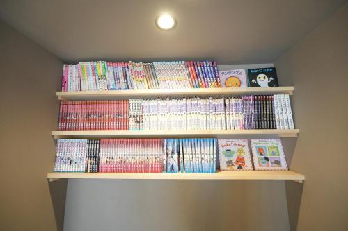 a book shelf filled with dvds and books at Suzuka Circuit 15min Family House鈴鹿サーキット15分 段差無し子連れ大歓迎漫画おもちゃいっぱいの一棟貸切宿 in Kameyama