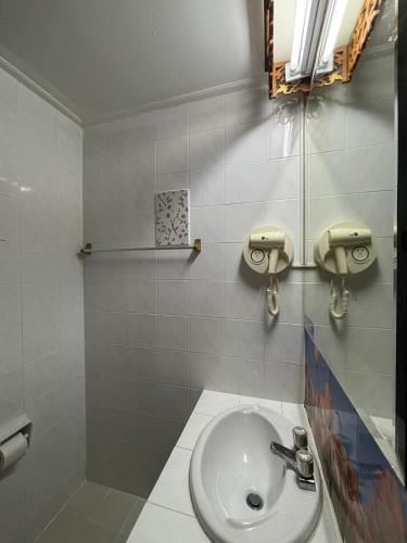 a bathroom with a sink and a toilet at โรงแรมรอยัลจอมมณี เฮอริเทจ in Ban Na Kai