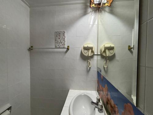 a bathroom with a toilet and a sink at โรงแรมรอยัลจอมมณี เฮอริเทจ in Ban Na Kai
