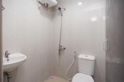 a bathroom with a shower and a toilet and a sink at Hanna Residence near RSPI Puri Indah Mitra RedDoorz in Meruya-hilir