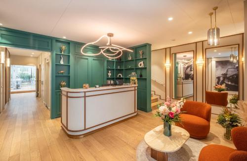 a lobby with green walls and a bar with a table at Dièse Hôtel Bastille in Paris
