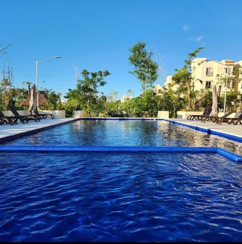 a swimming pool with blue water in a resort at Nare bokova in Tulum