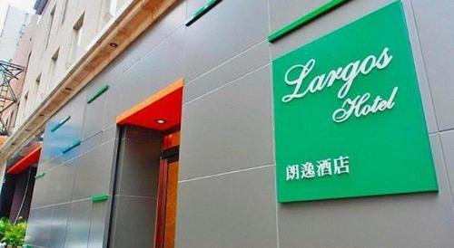a green sign on the side of a building at Largos Hotel in Hong Kong